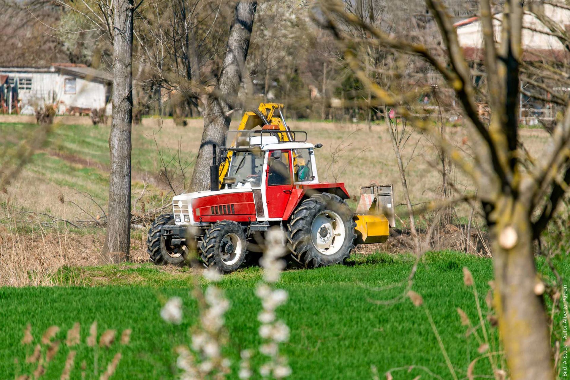 Rot-weißer Traktor beim Graben reinigen