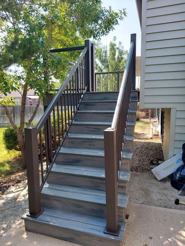 A set of stairs leading up to a deck next to a house.