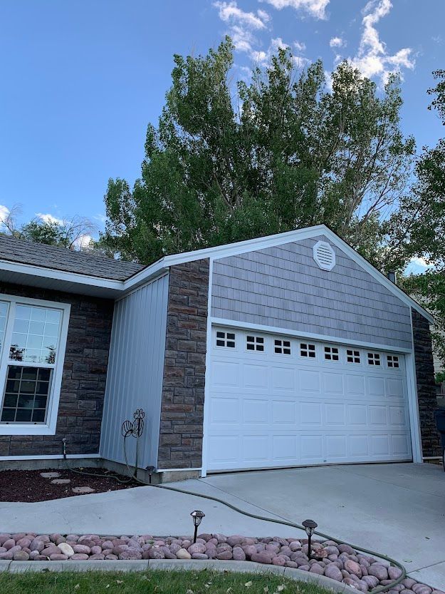 A house with a white garage door and a brick wall.