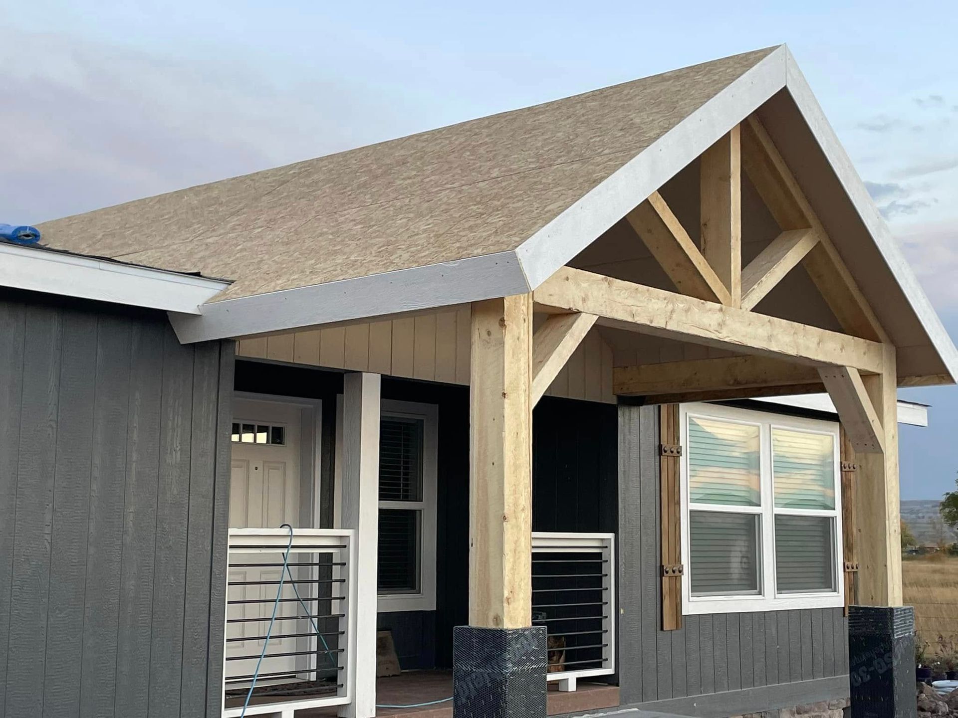 A small house with a porch and a roof