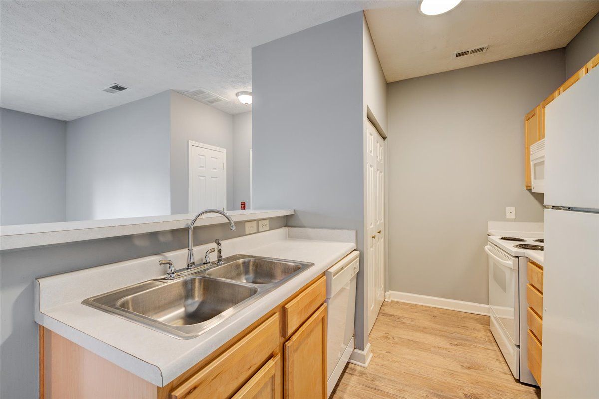 A kitchen with a sink , stove , refrigerator and dishwasher.