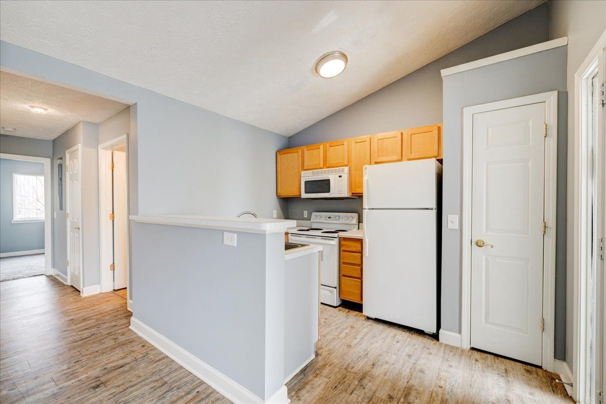 A kitchen with a refrigerator , microwave , and sink.