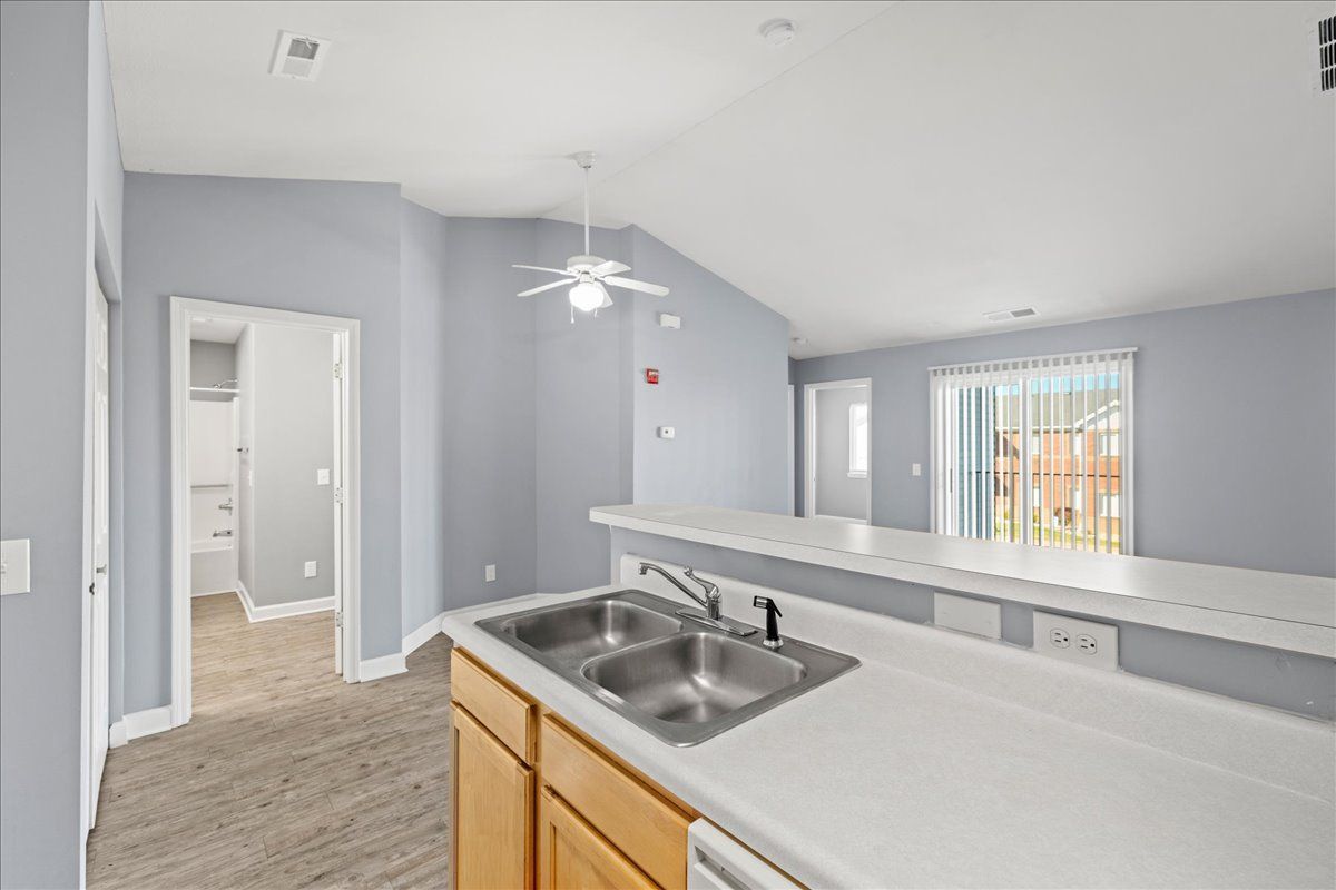 A kitchen with two sinks and a ceiling fan.