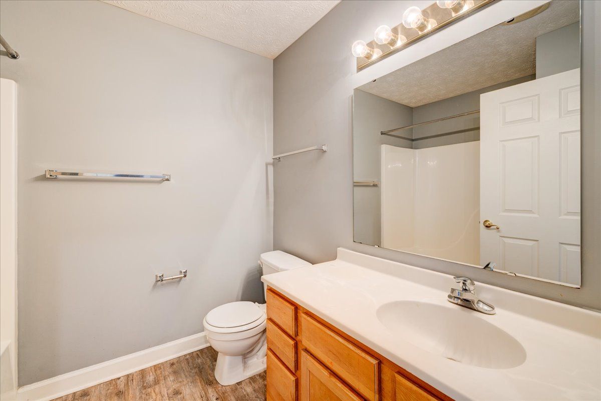 A bathroom with a toilet , sink , and mirror.
