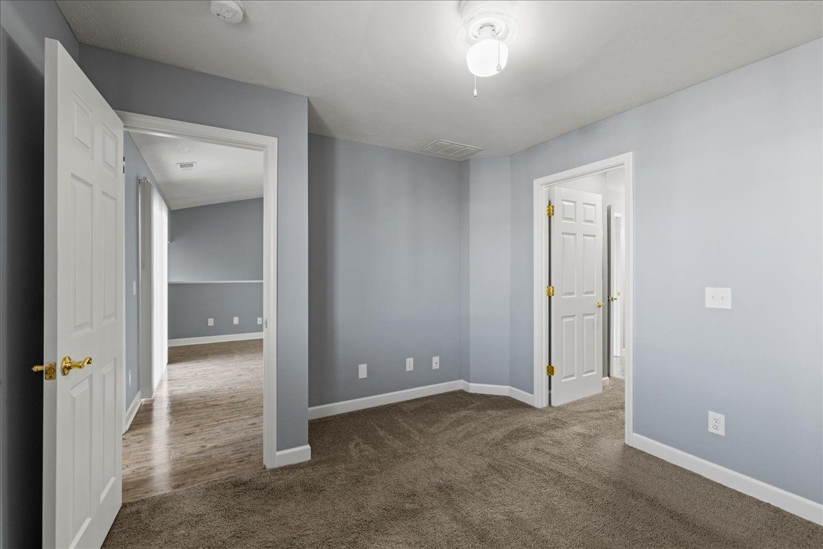 There is a ceiling fan in the room and a carpeted floor.
