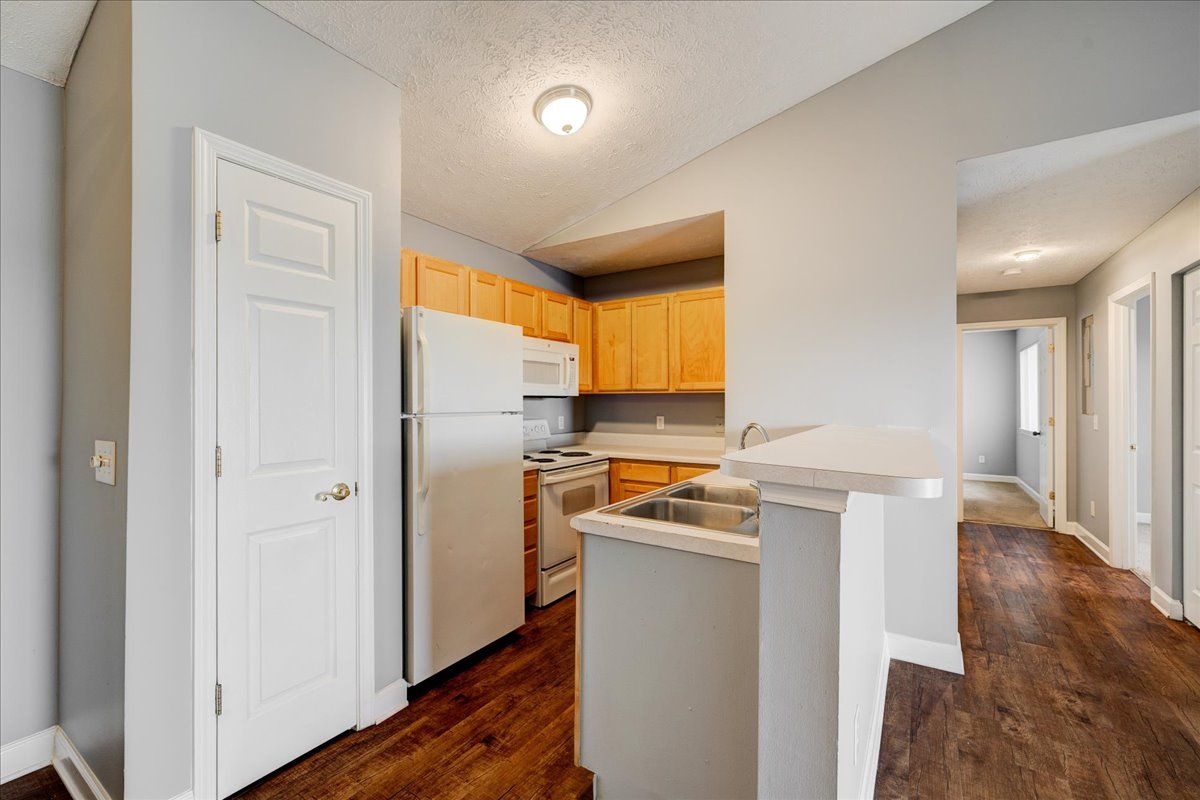 A kitchen with a refrigerator , stove , sink , and cabinets.
