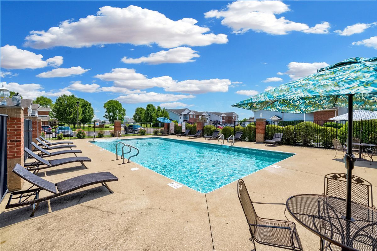 A large swimming pool with chairs and umbrellas around it