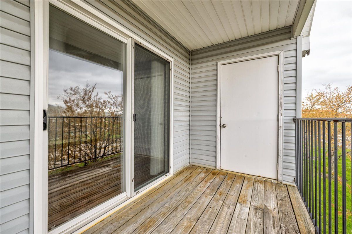 A balcony with sliding glass doors and a white door.