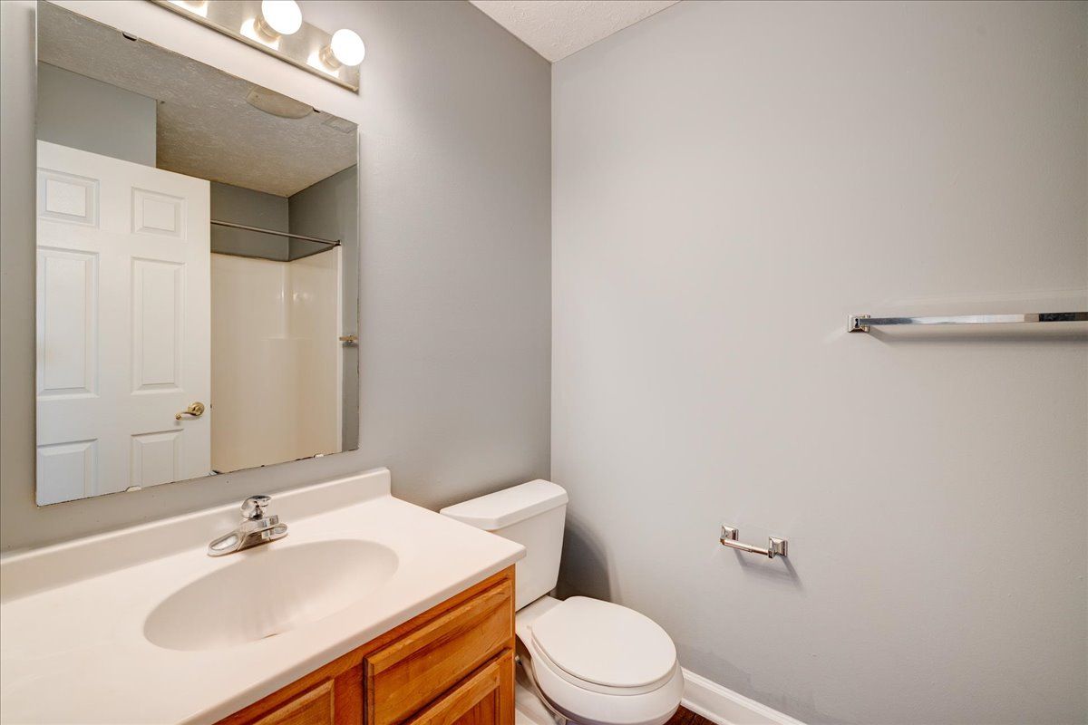 A bathroom with a sink , toilet and mirror.