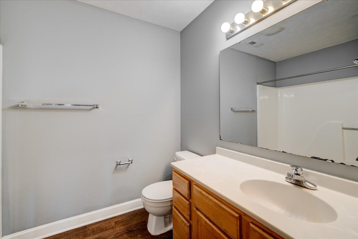 A bathroom with a toilet , sink , and mirror.