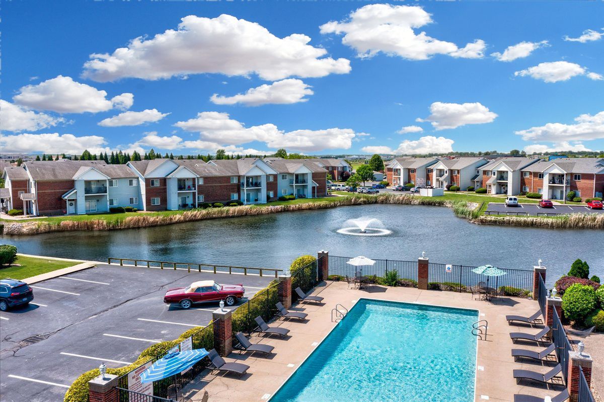An aerial view of a swimming pool with a lake in the background