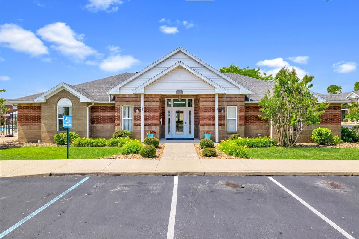 A large brick building with a parking lot in front of it.