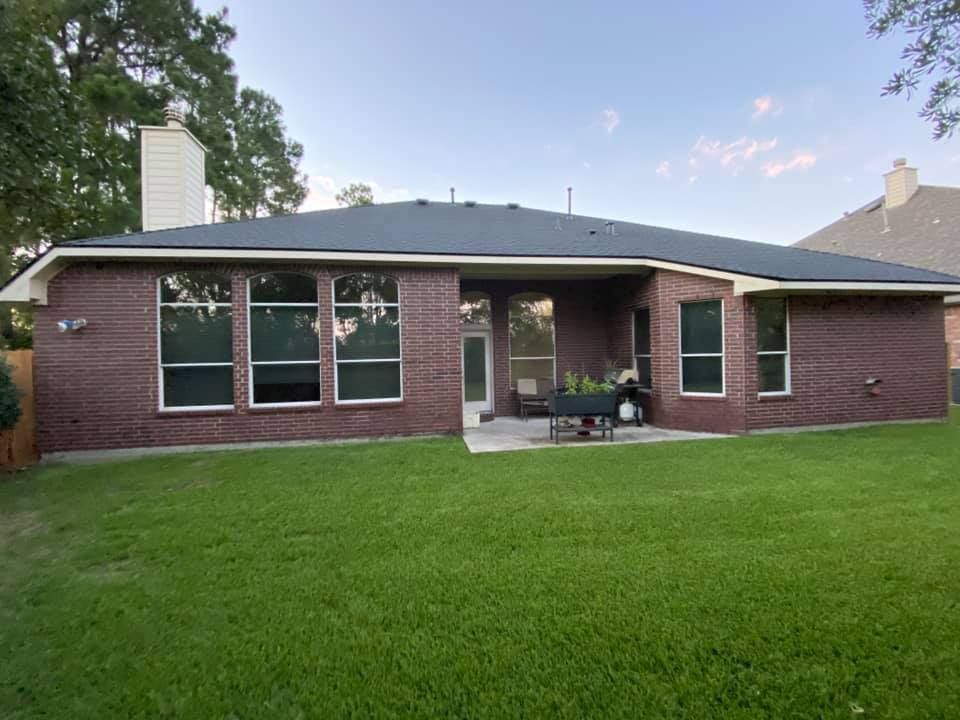 A brick house with a large lawn in front of it