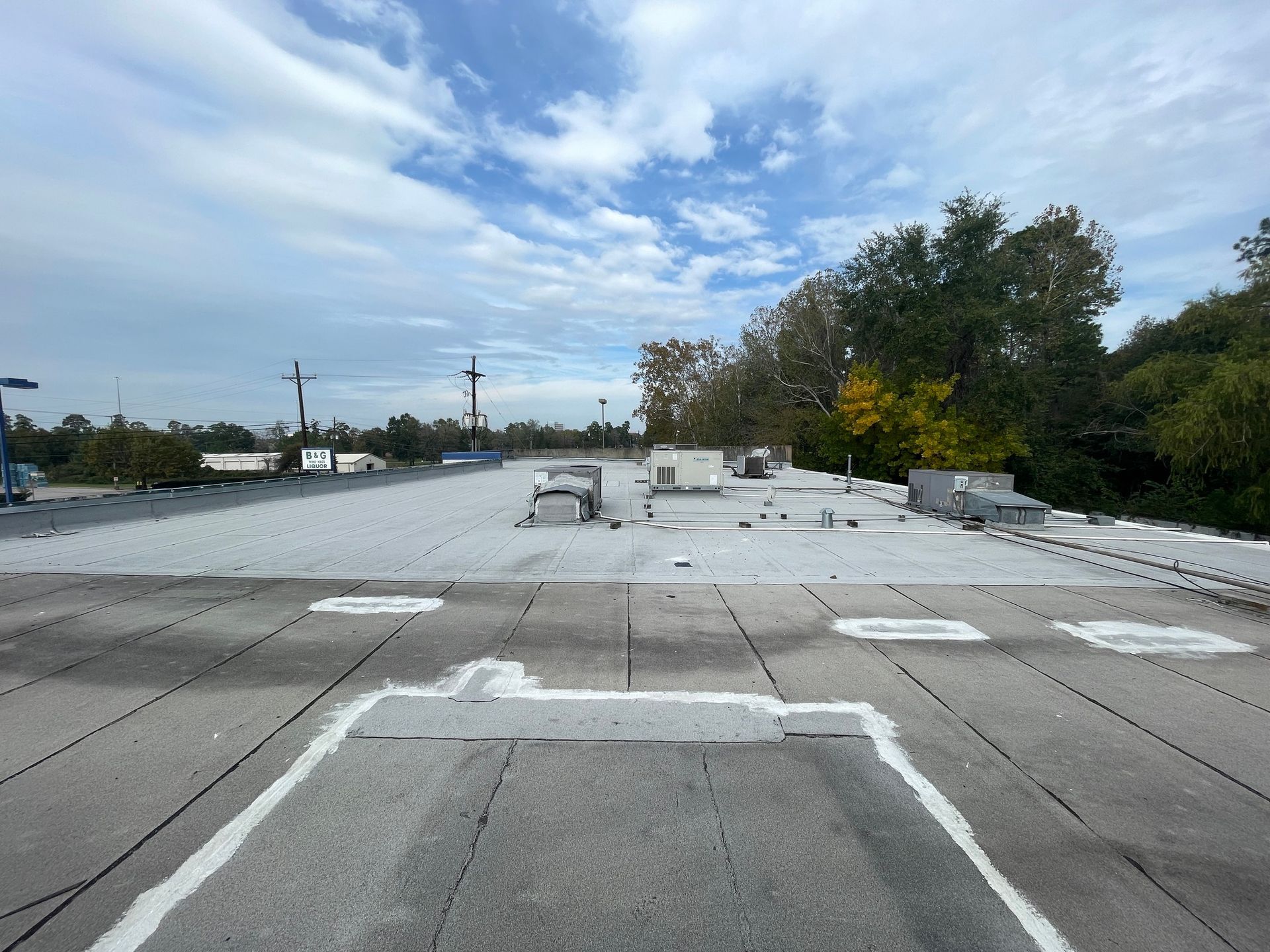 The roof of a building with a lot of trees in the background