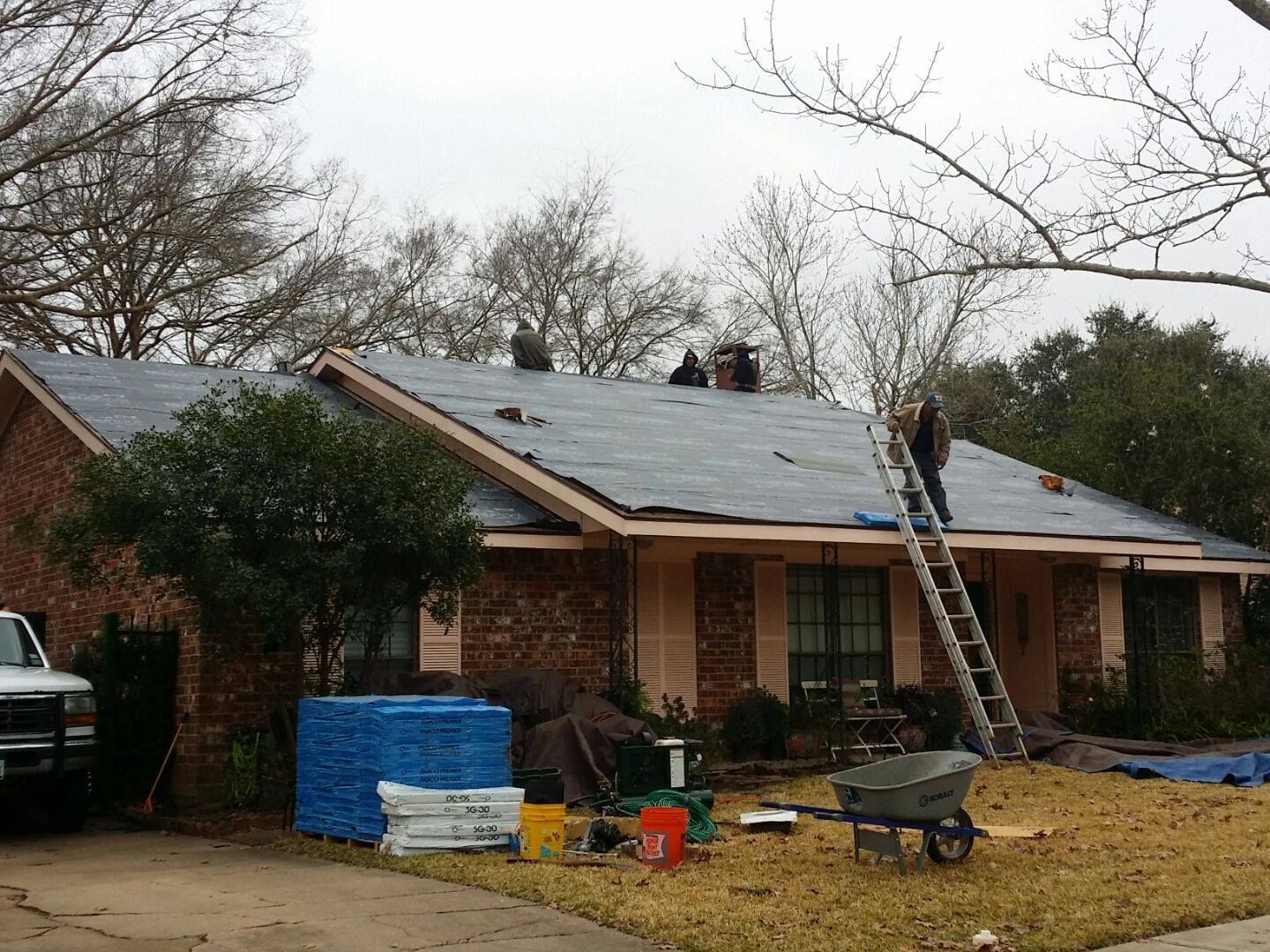 A roof is being installed on a brick house