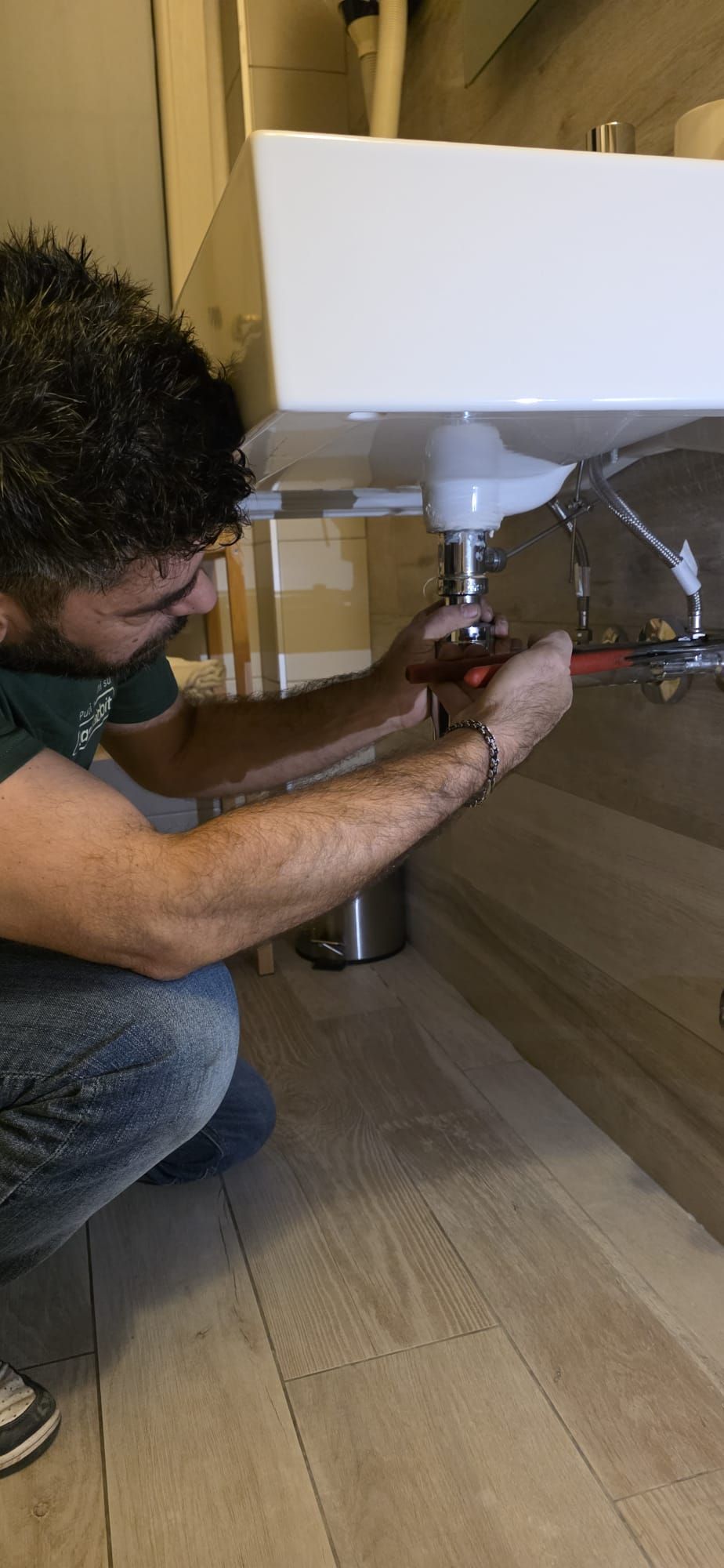 Mobile porta TV in legno e contenitore a parete con rivestimento protettivo su una parete bianca, in una stanza vuota.