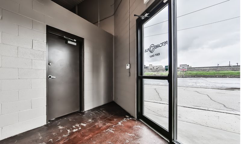 A hallway with a door and a large window.