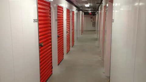 A long hallway with red doors and white walls
