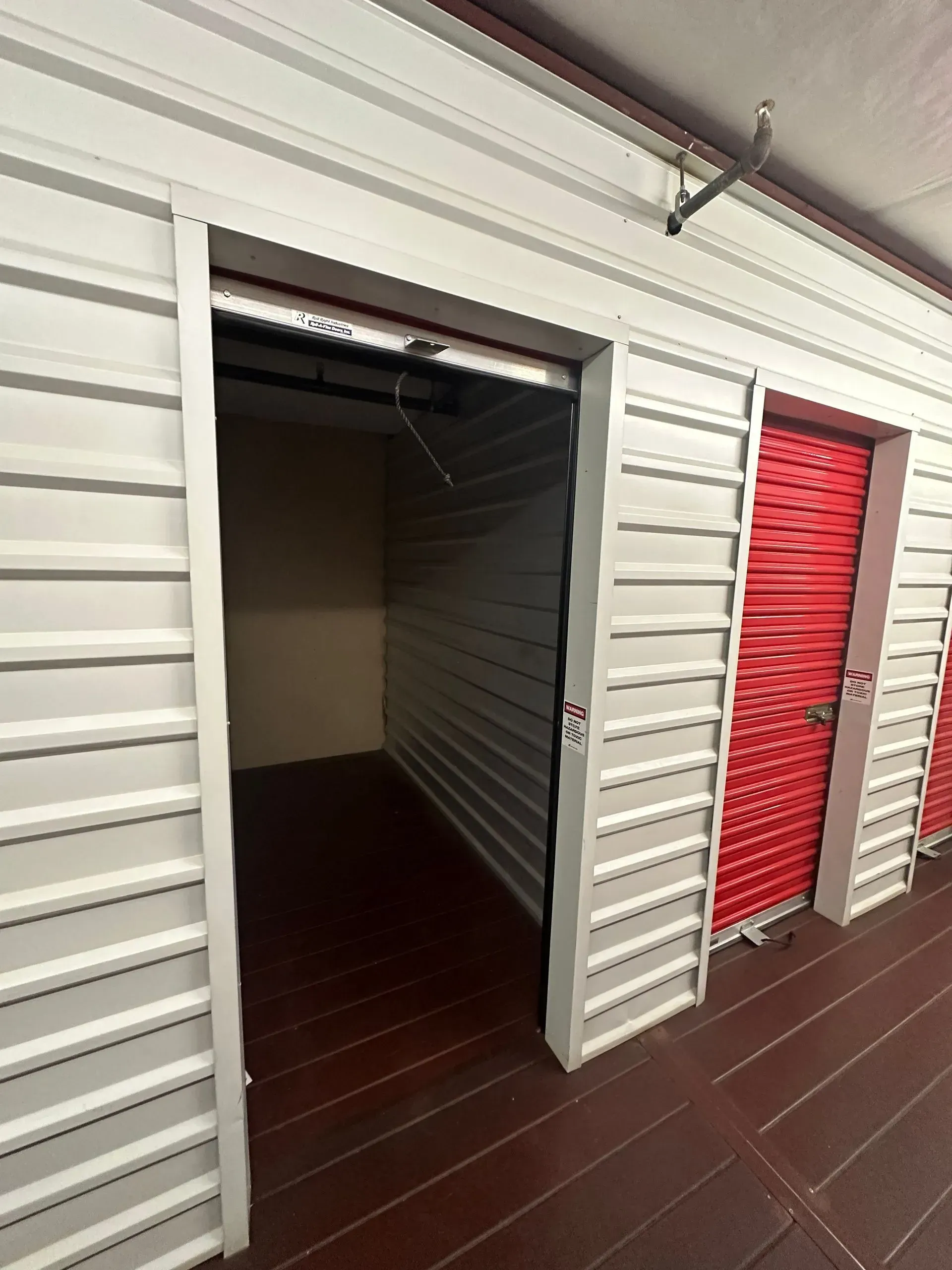 A row of empty storage units with red doors.