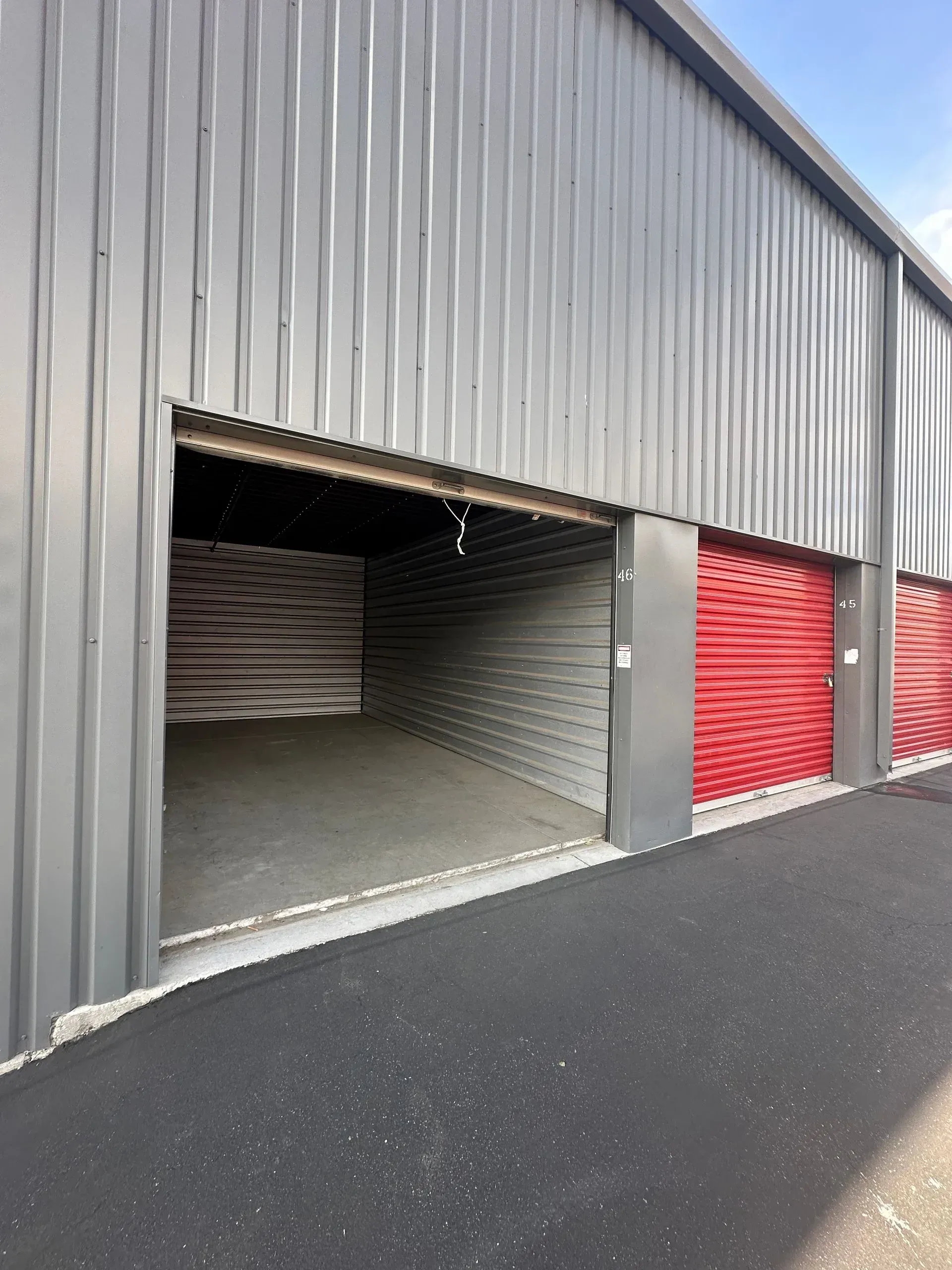 A row of empty storage units with red doors.