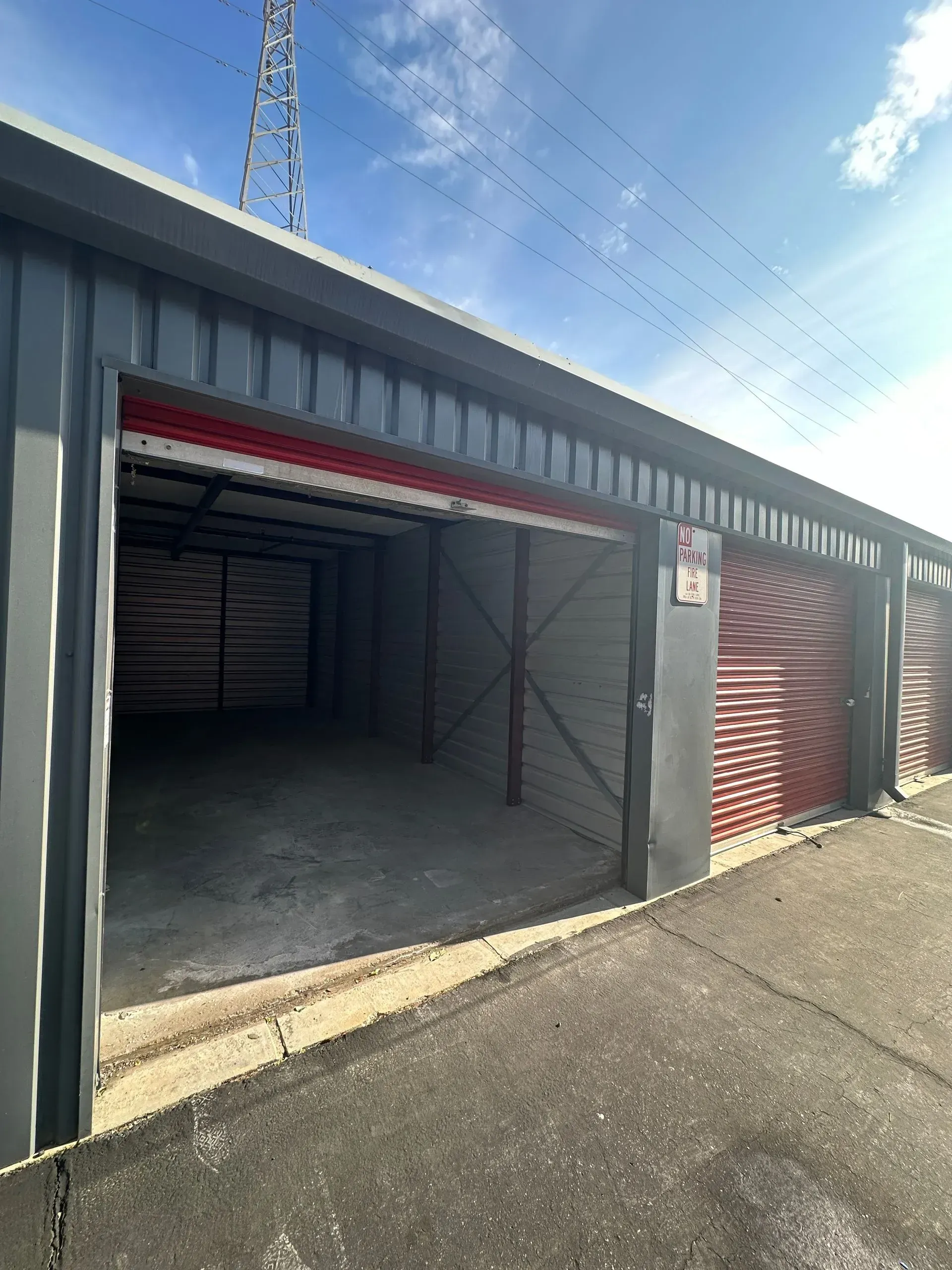 A row of garages with their doors open on a sunny day.