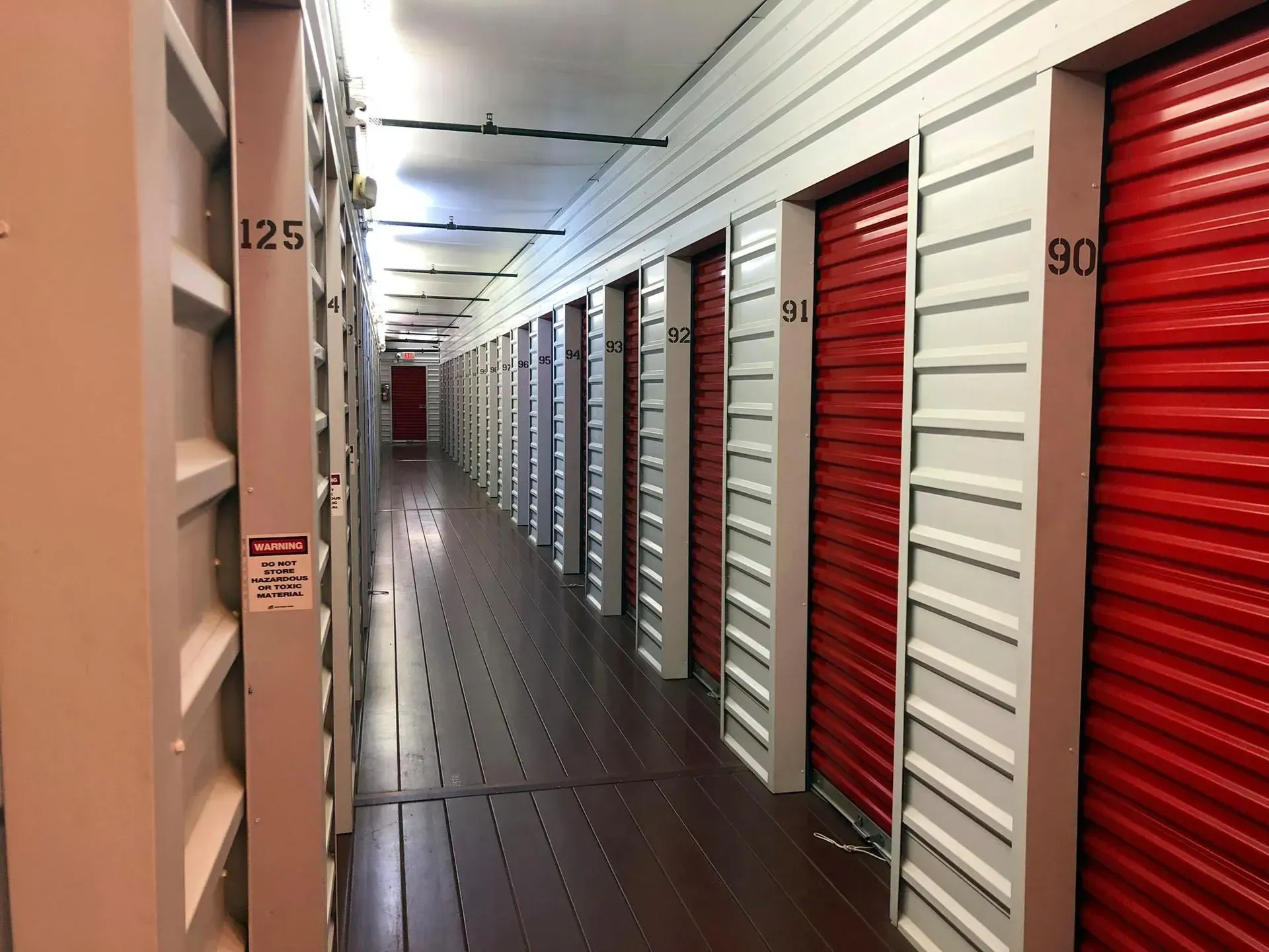 A long hallway filled with red and white storage units