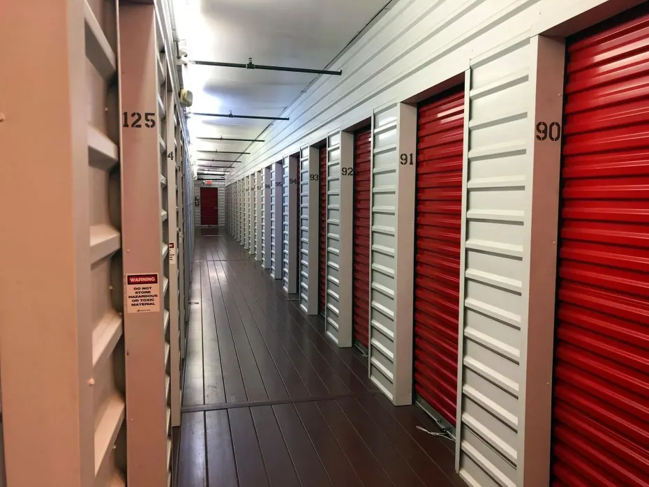 A long hallway filled with red and white storage units