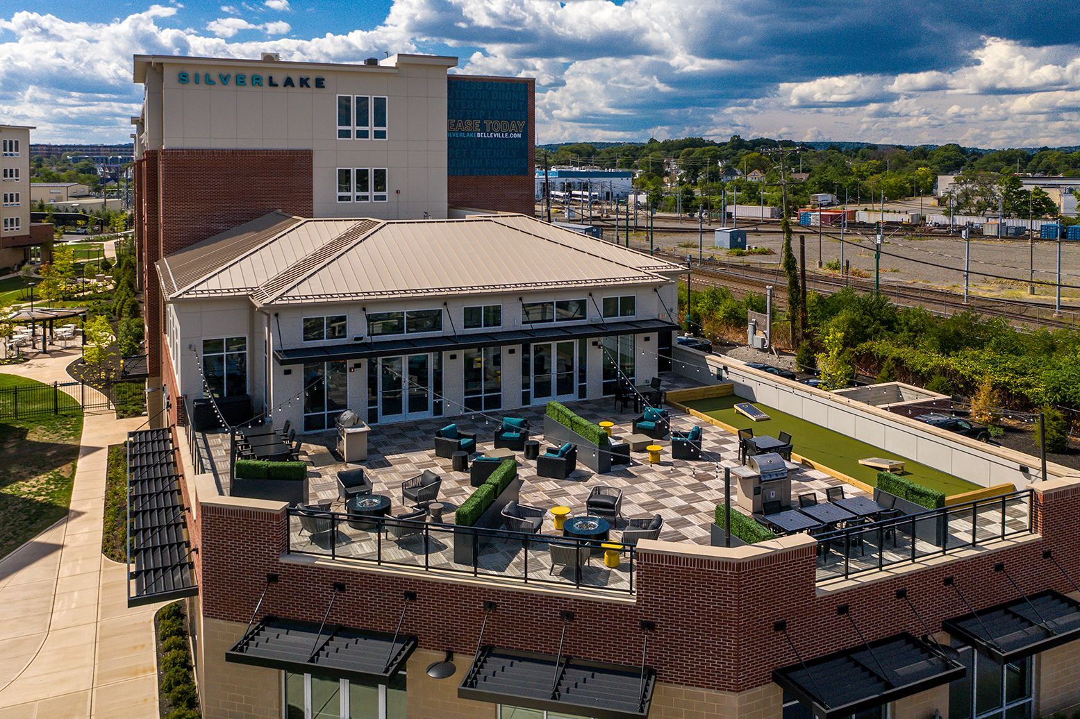 Rooftop patio with seating, part of a building labeled 