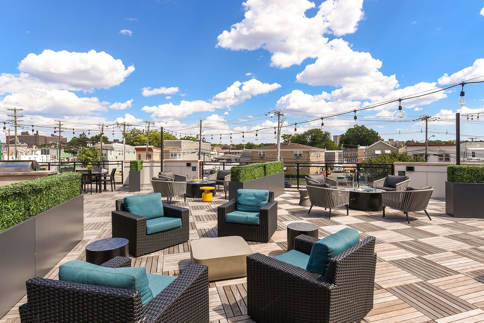 Rooftop patio with seating, string lights, and blue skies.