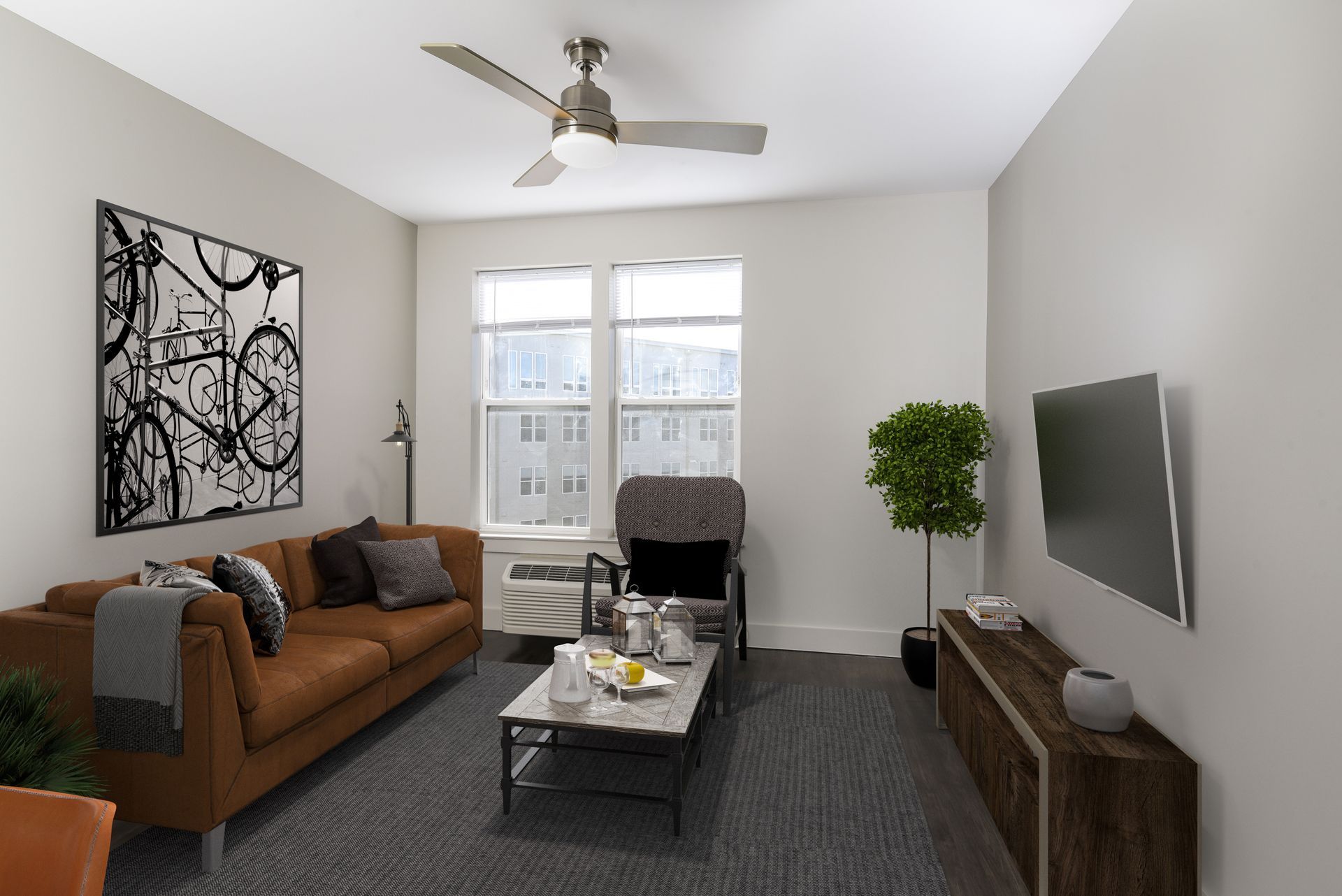 Living room with brown sofa, artwork, TV, window, and rug.