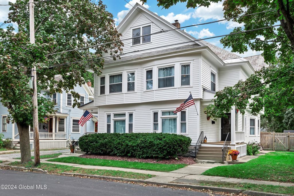 A large white house with an american flag in front of it