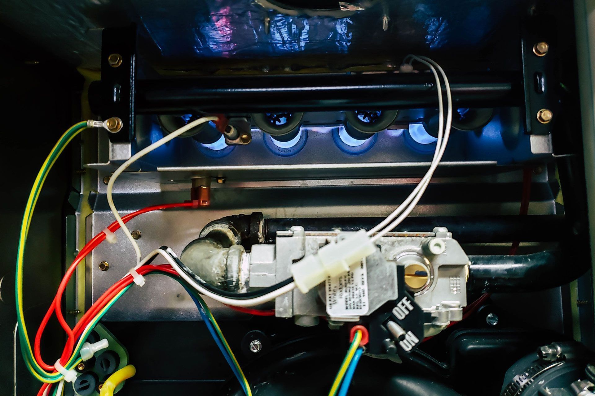 A close up of a stove with a bunch of wires coming out of it.