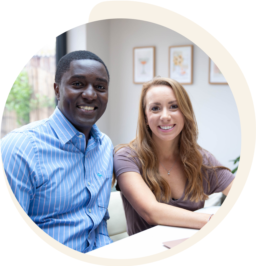 A man and a woman are sitting next to each other and smiling for the camera.