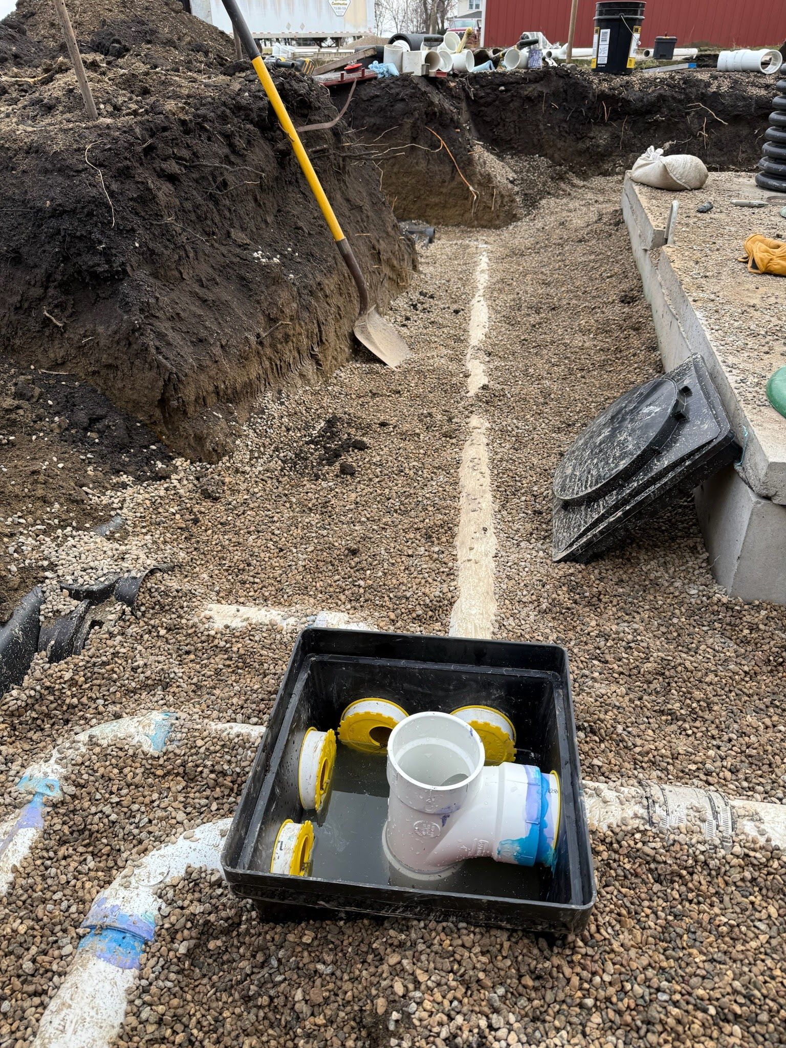 A man is welding a pipe in the dirt.