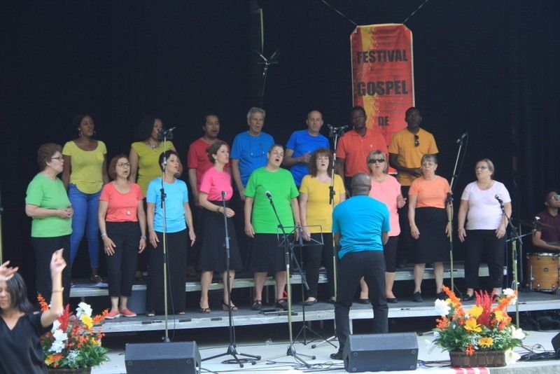Un groupe de personnes chantant devant un panneau indiquant « festival gospel »