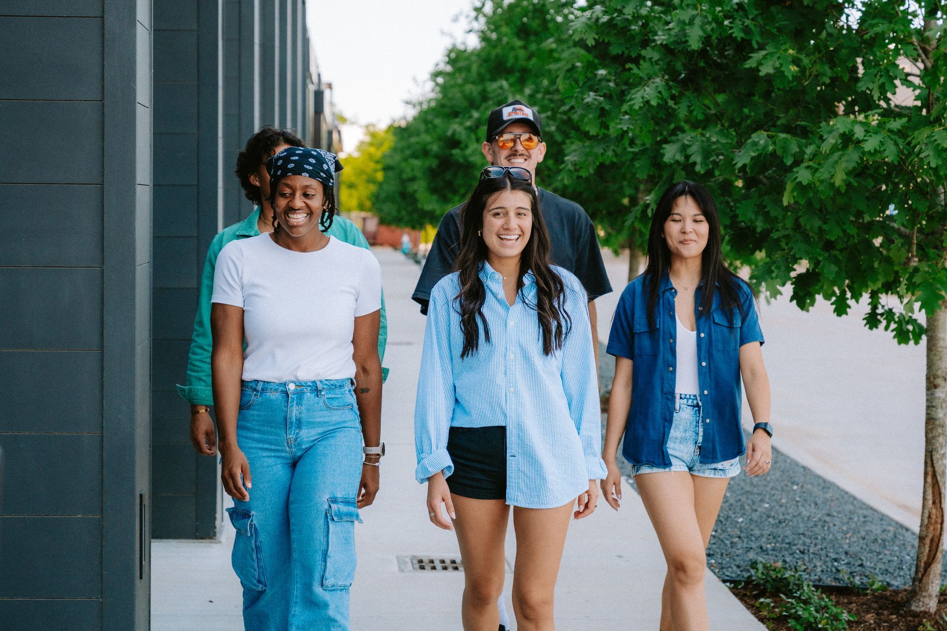 A group of women are posing for a picture in front of a building