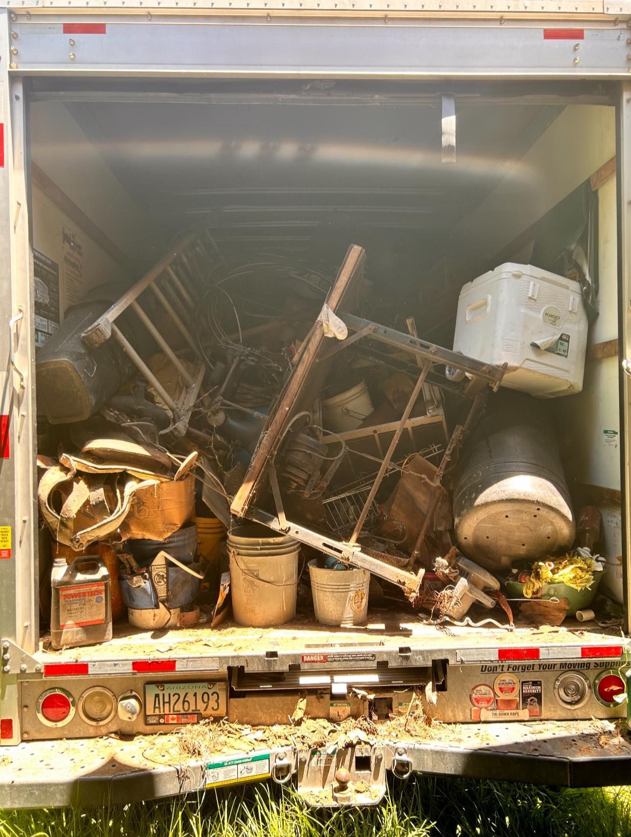 The back of a truck is filled with lots of junk.