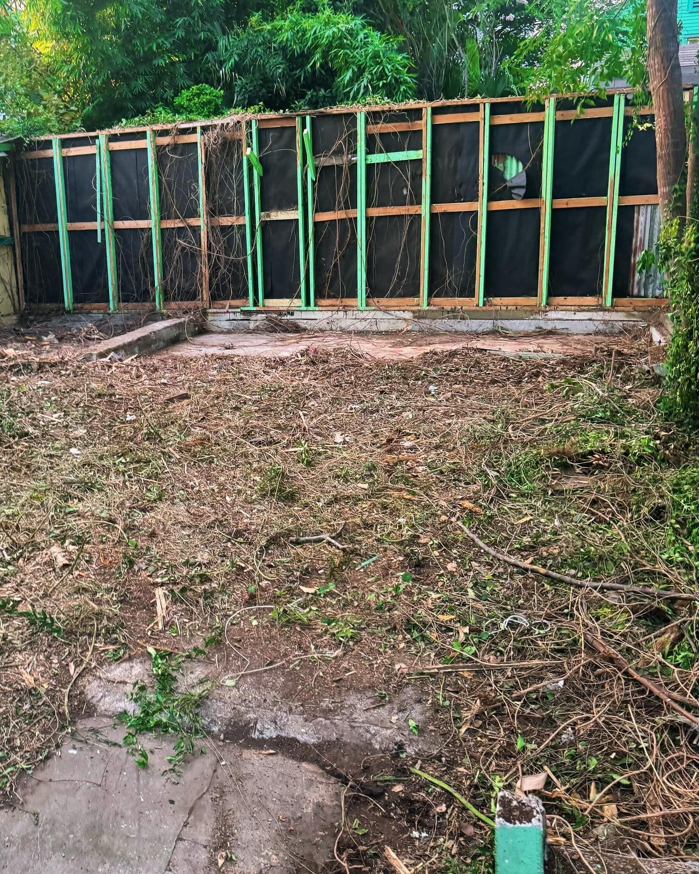 A fence is being built in the backyard of a house.