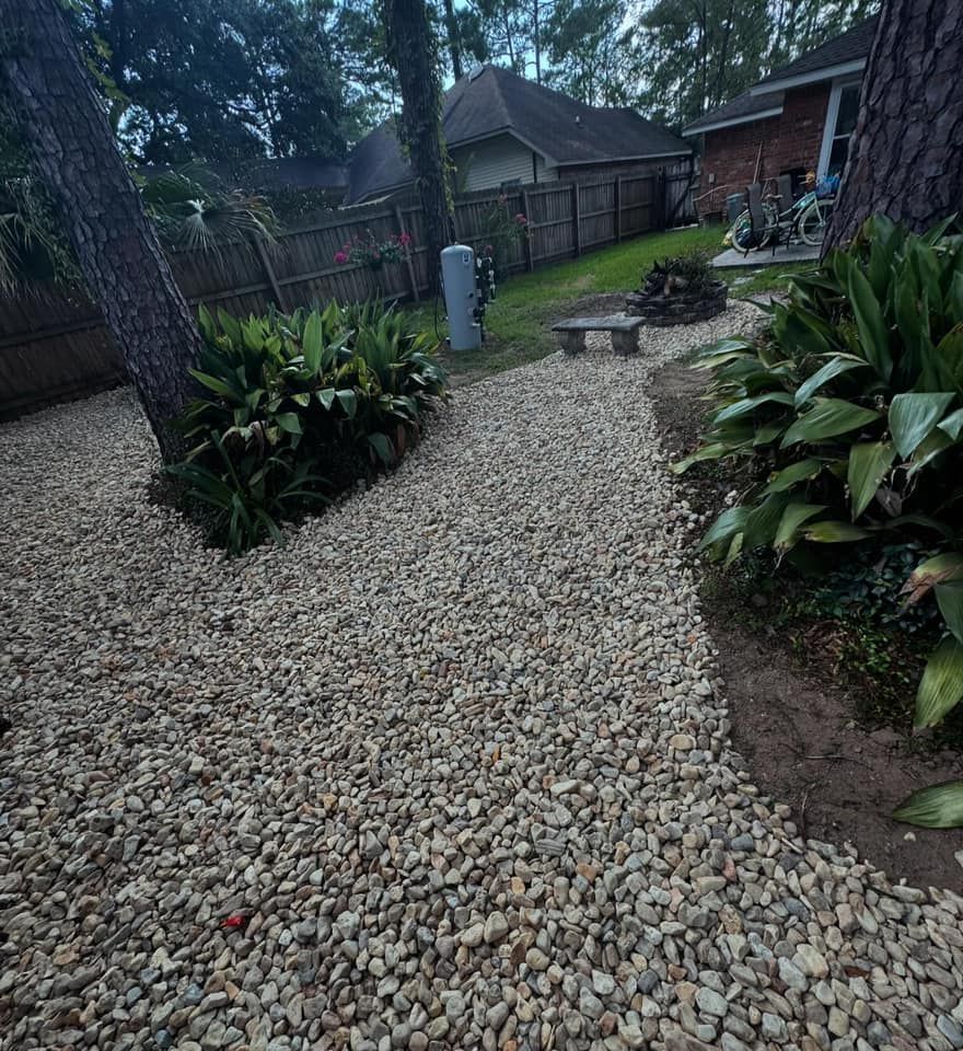 A gravel path leading to a fire pit in a backyard.