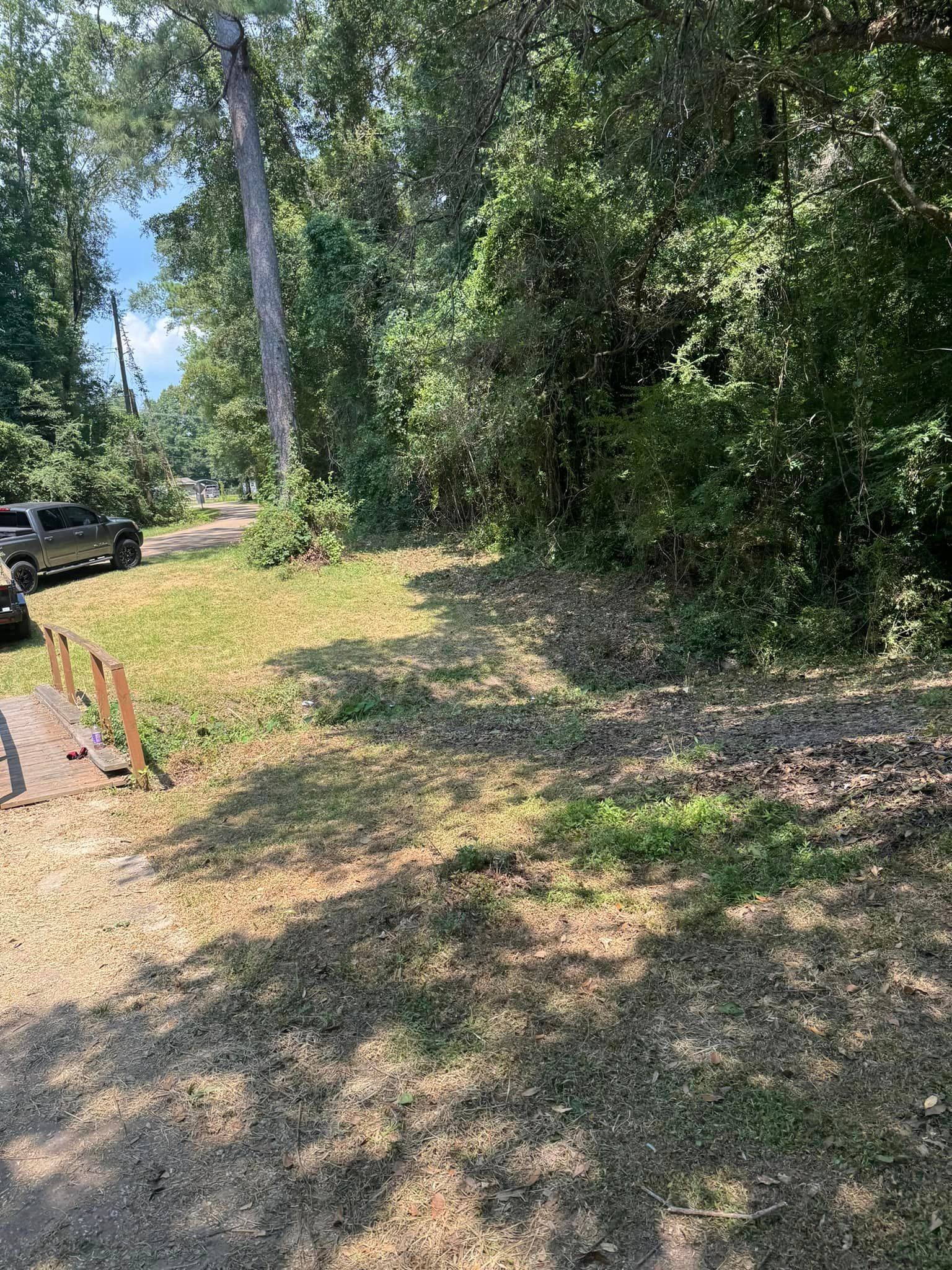 A park bench is sitting in the middle of a grassy field surrounded by trees.