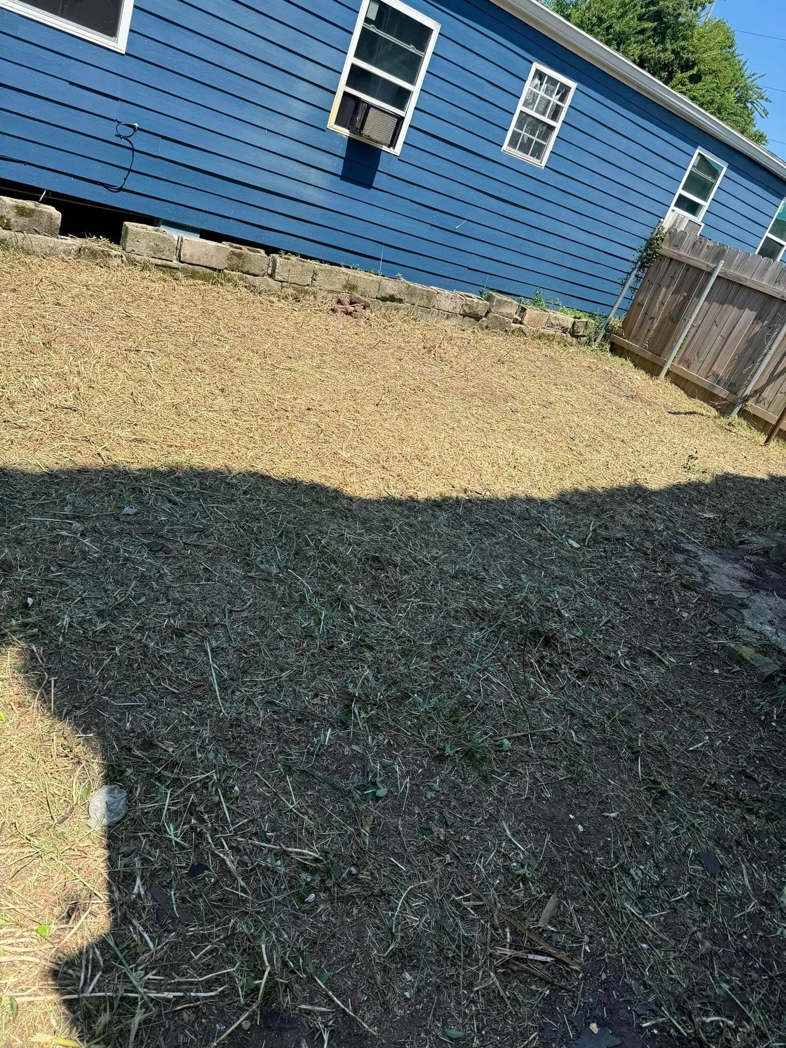 A blue house with a lot of gravel in front of it.