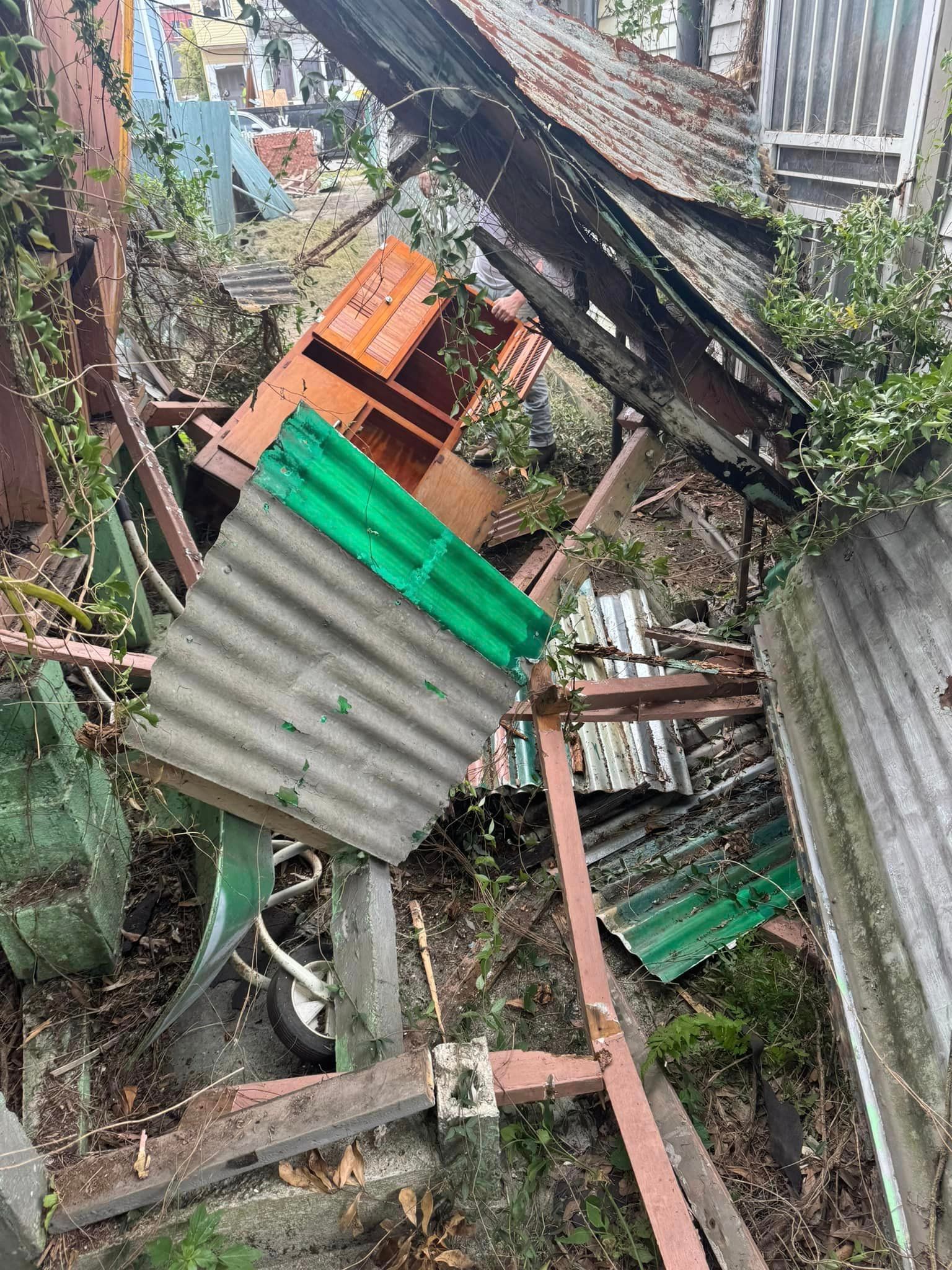 A pile of junk is sitting on the ground in front of a building.