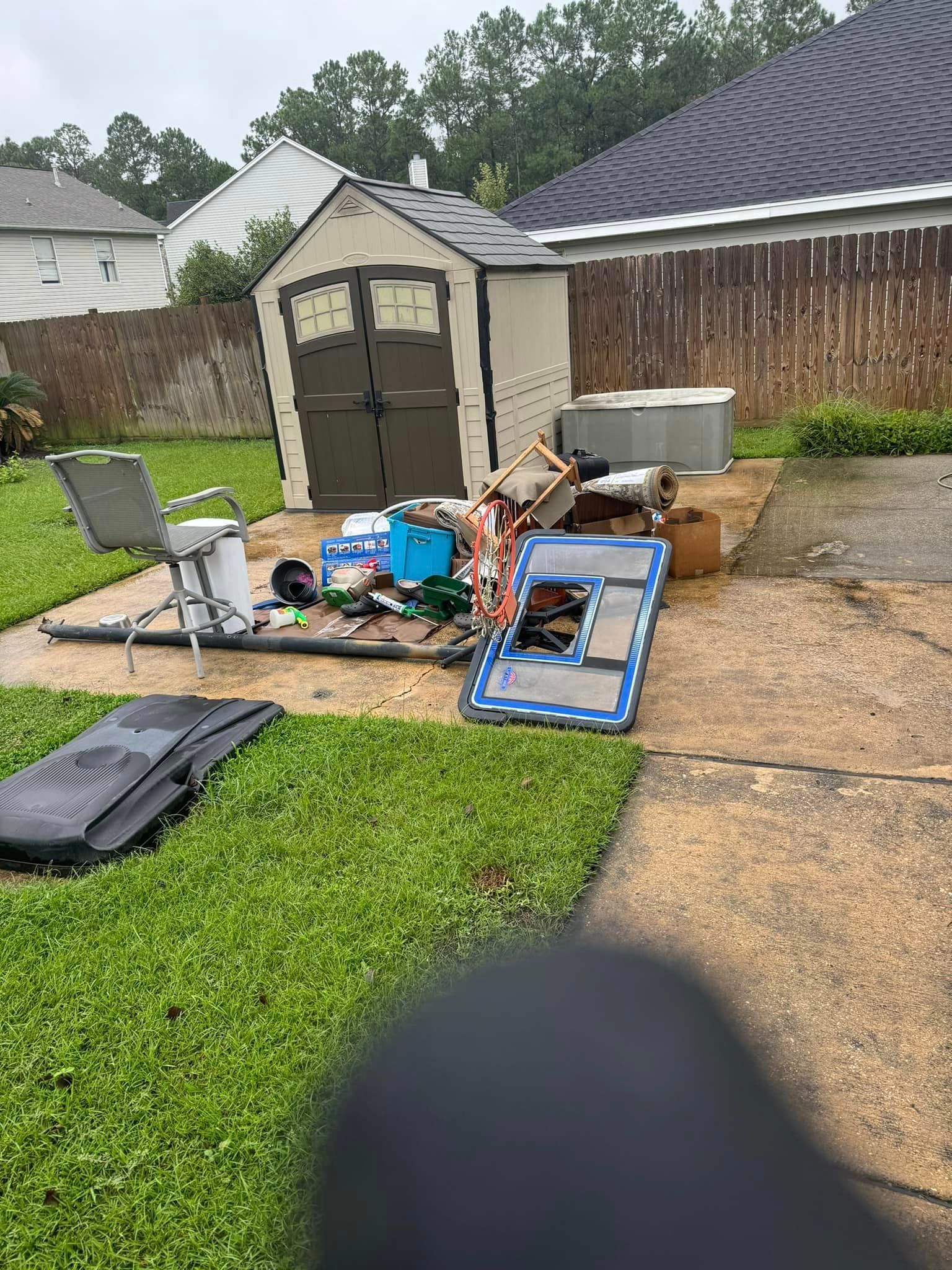 A backyard filled with lots of trash and a shed.