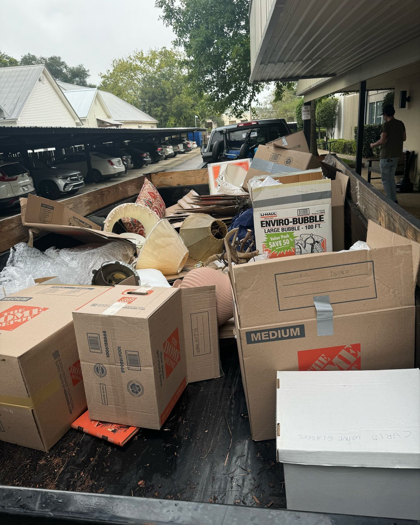 A dumpster filled with lots of cardboard boxes and trash.