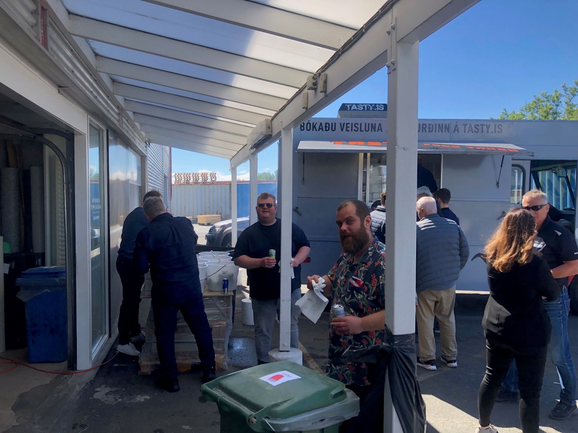 Hópur fólks stendur undir yfirbyggðri gangbraut.