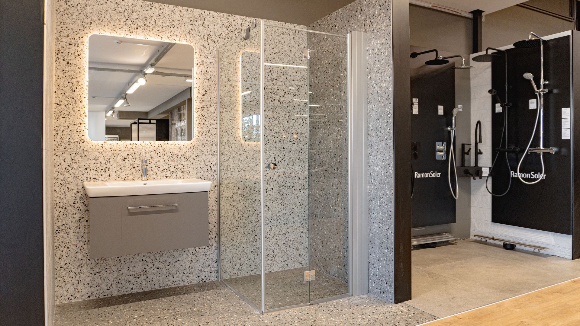 Baðherbergi með sturtuklefa, vaski og spegli.