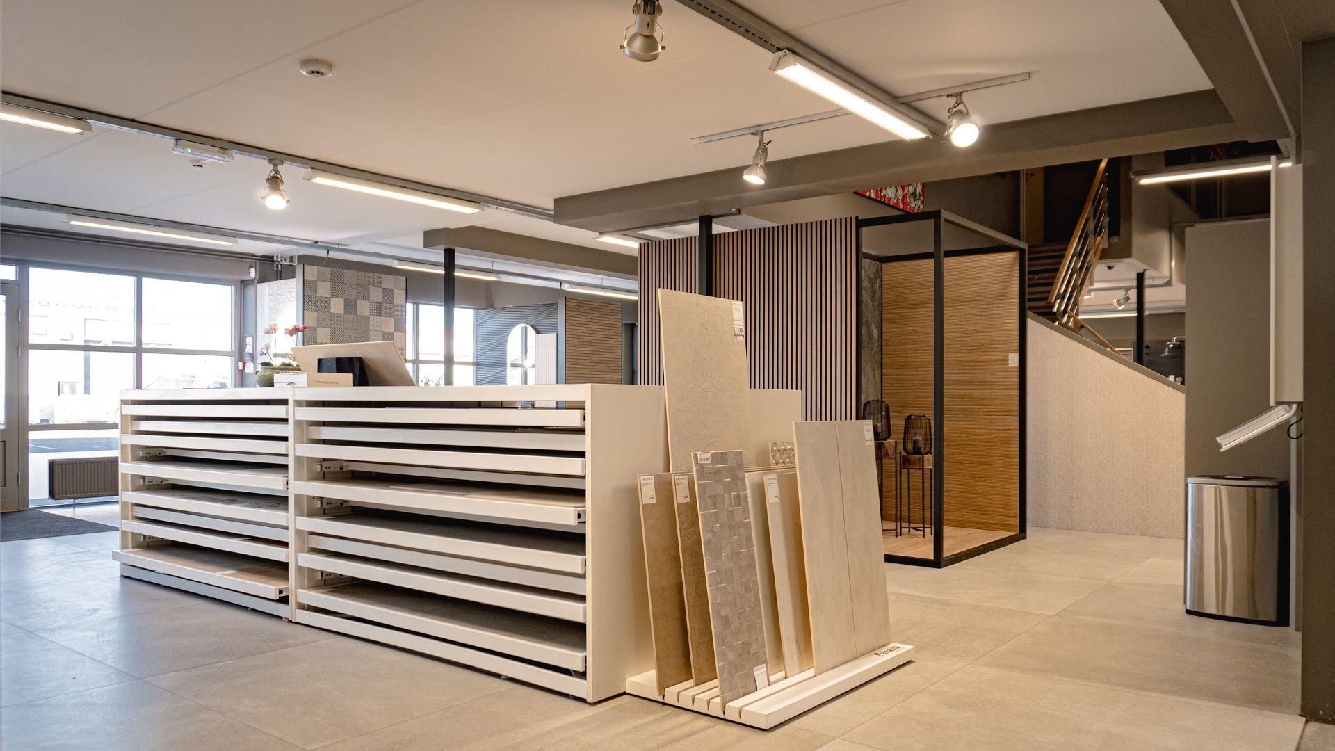 Stórt herbergi með fullt af hillum og stigi í bakgrunni.