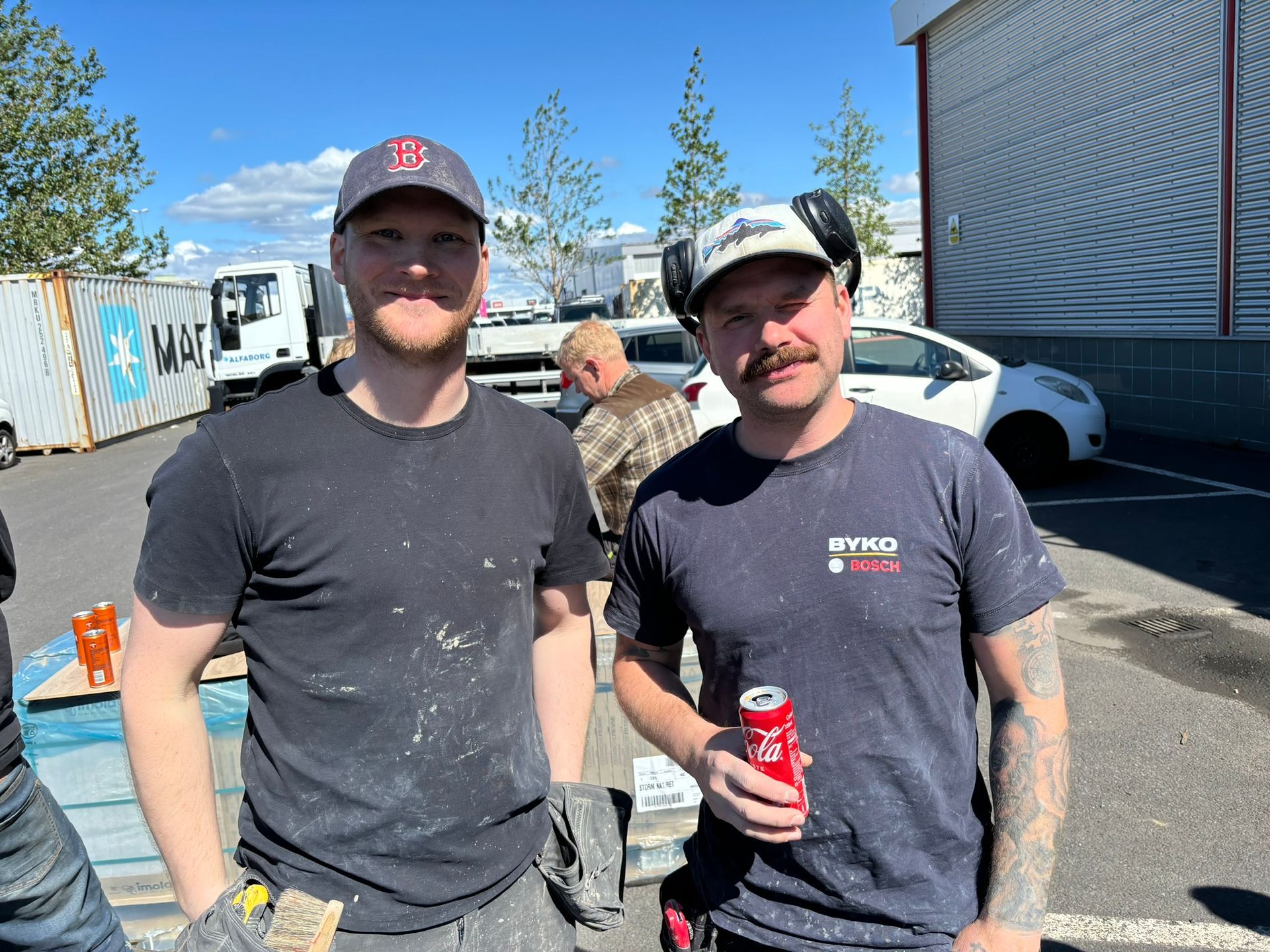 Tveir menn standa við hlið hvors annars og einn heldur á gosdós.