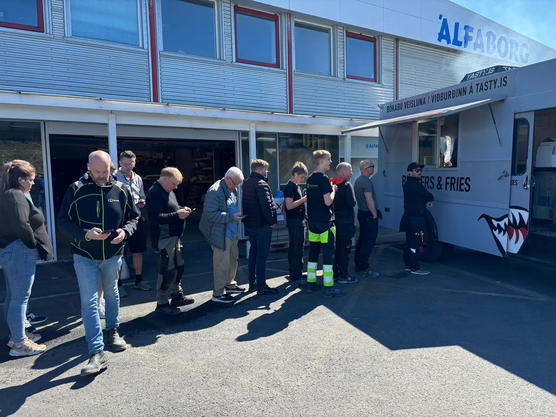 Hópur fólks stendur fyrir framan matarbíl.