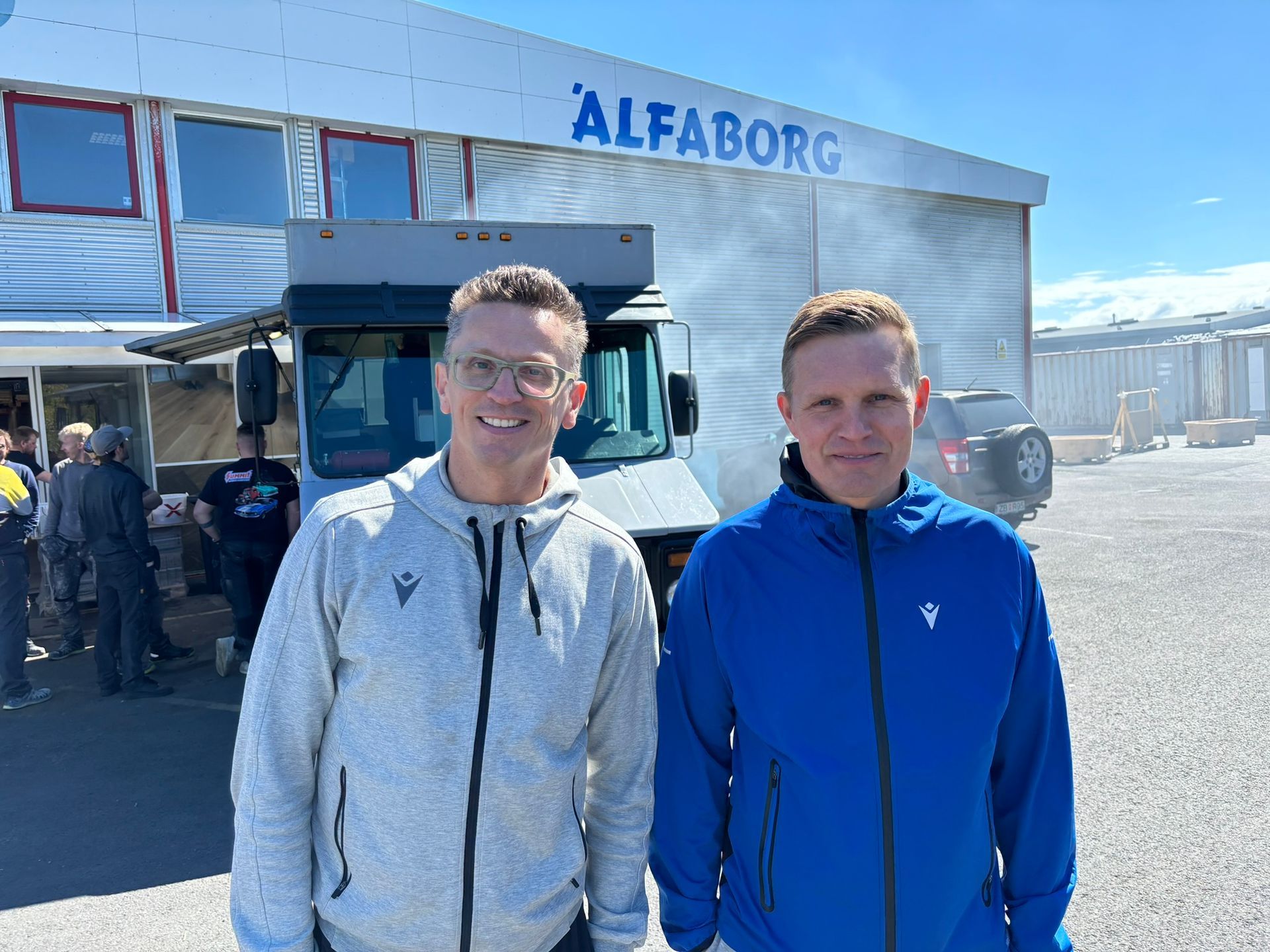 Tveir menn standa fyrir framan byggingu sem segir Alfaborg.